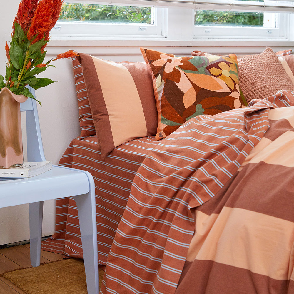 Rust pinstripe sheet set, flat lay with folded sheets and pillowcases